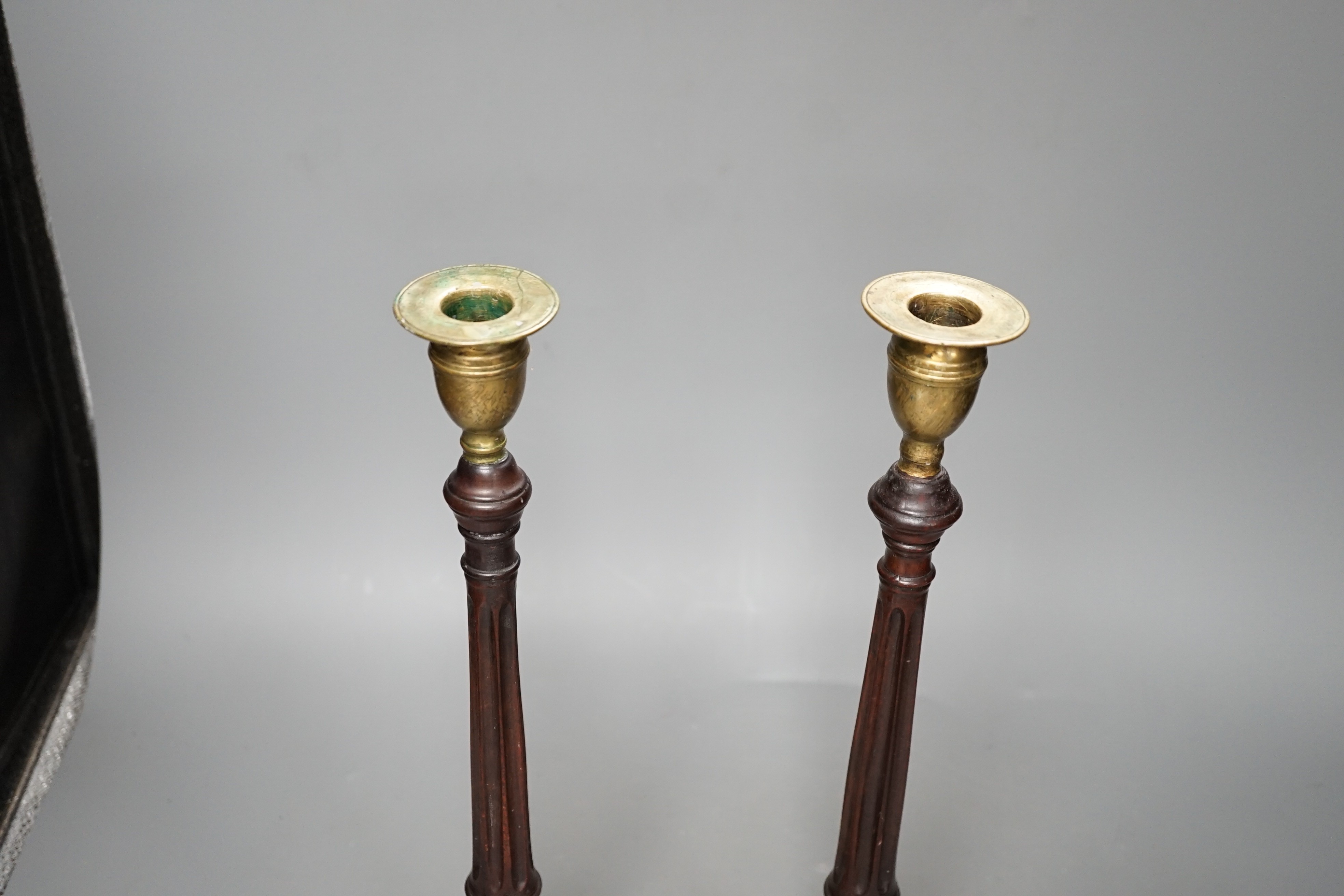 A pair of George III style carved mahogany candlesticks, with brass sconces, 38cms high